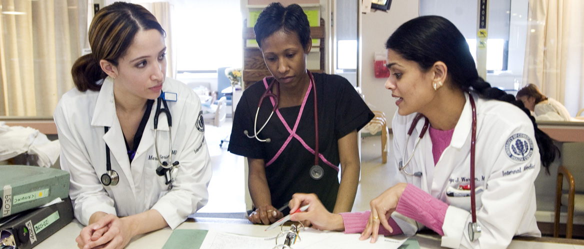 Residents Maria Soriano, M.D., left, and Priya Warrier, M.D., right, discuss a case with Constance Ebron, LPN, center, at the UConn Health Center.